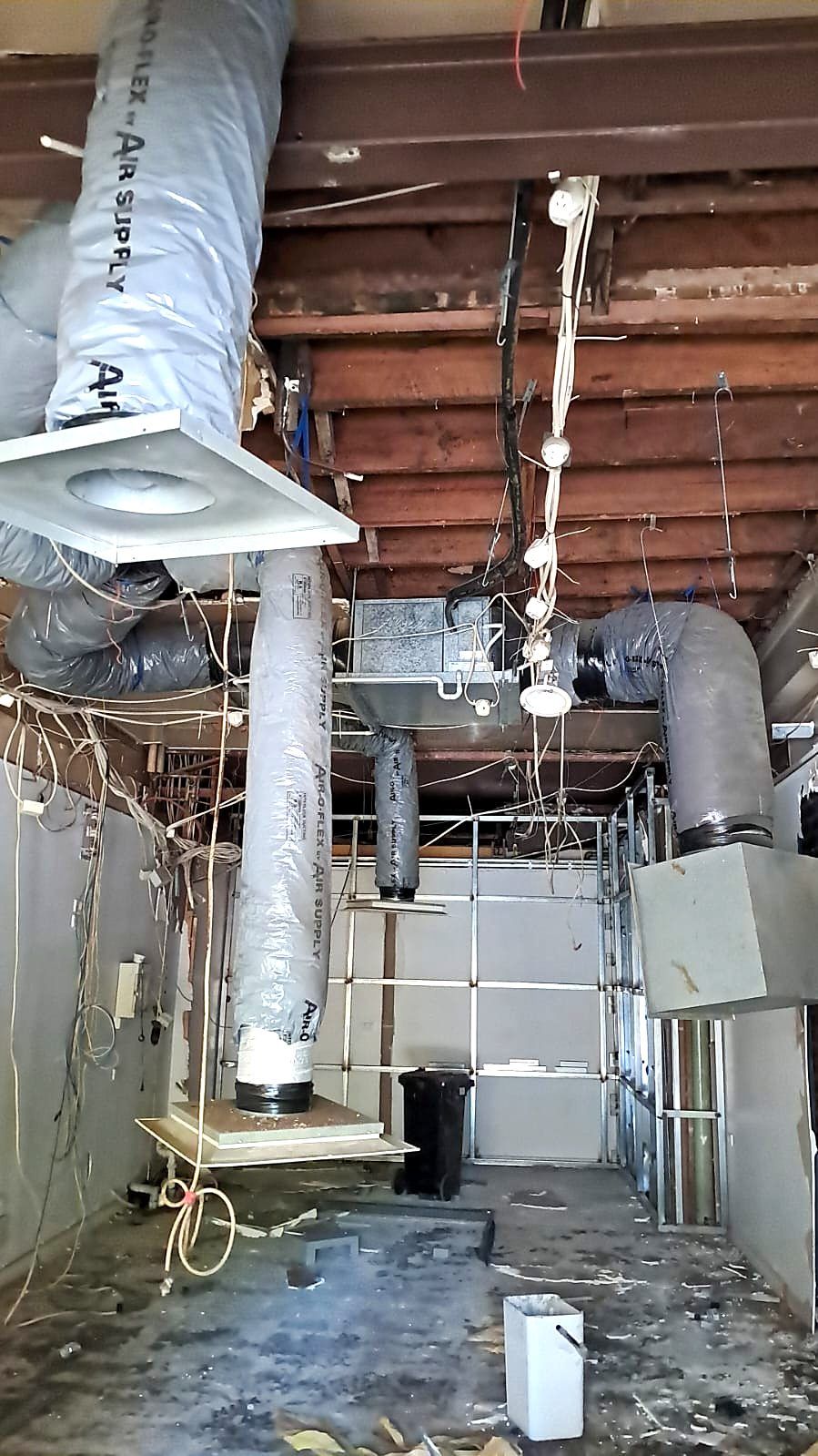 Demolition and strip-out exposing existing ceiling services in a Coburg shop renovation - Master Framers