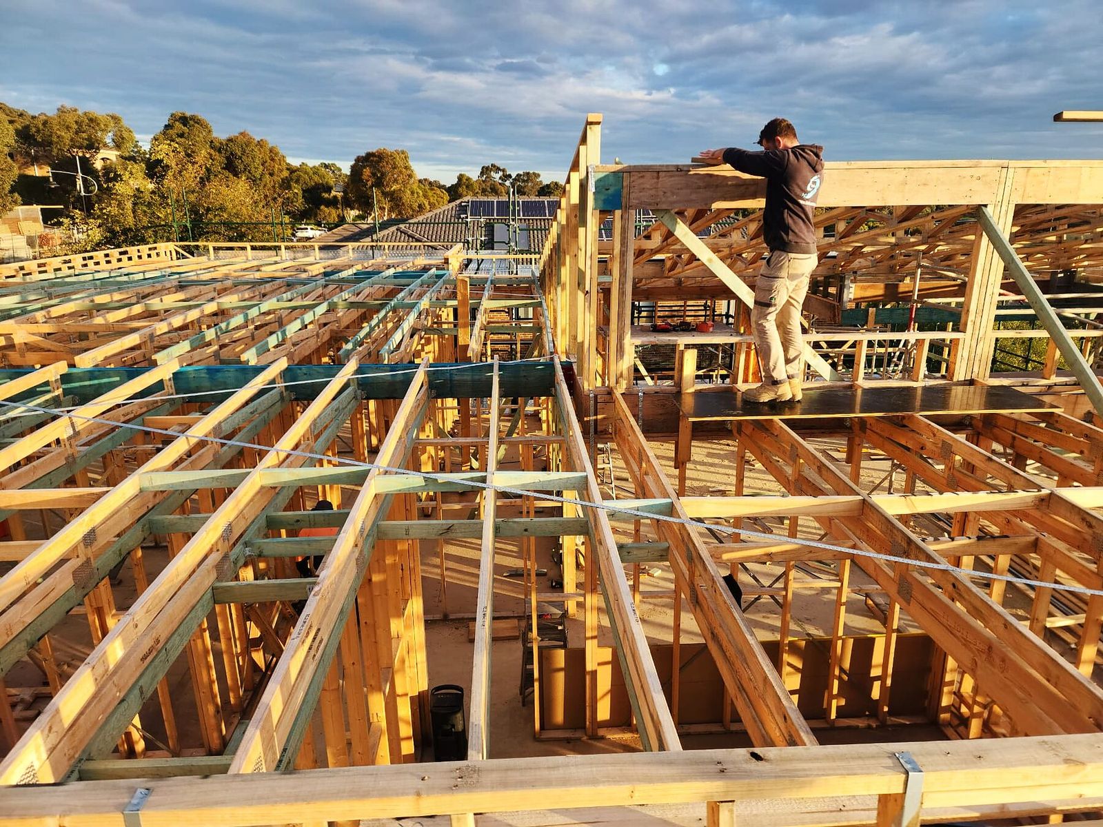 Carpenter setting out upper floor and wall framing on a Doreen custom home - Master Framers